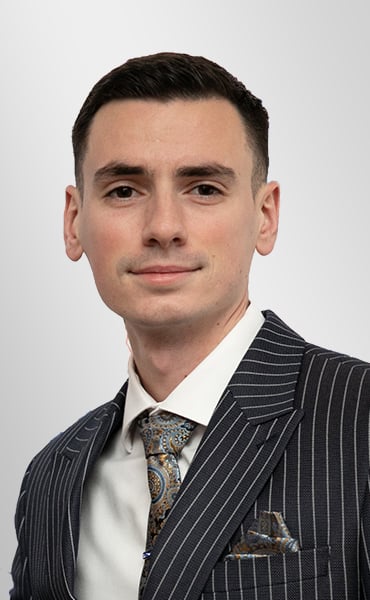Christopher Palmeri in a dark pinstripe suit and patterned tie.