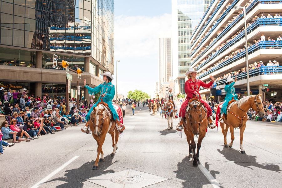 2 women riding horses in the Calgary Stampede parade 