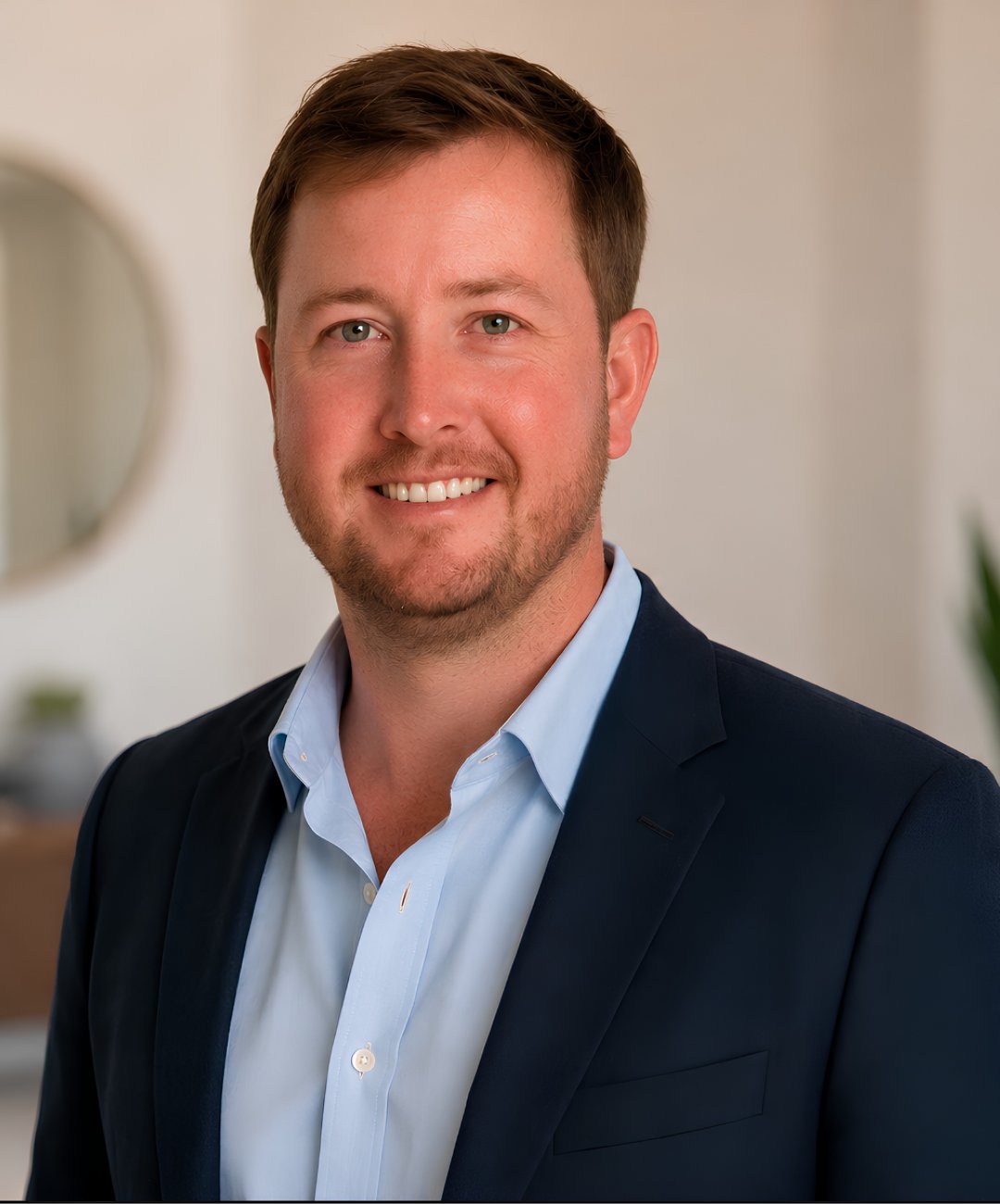 David Bushing smiling in a navy jacket and light blue shirt.