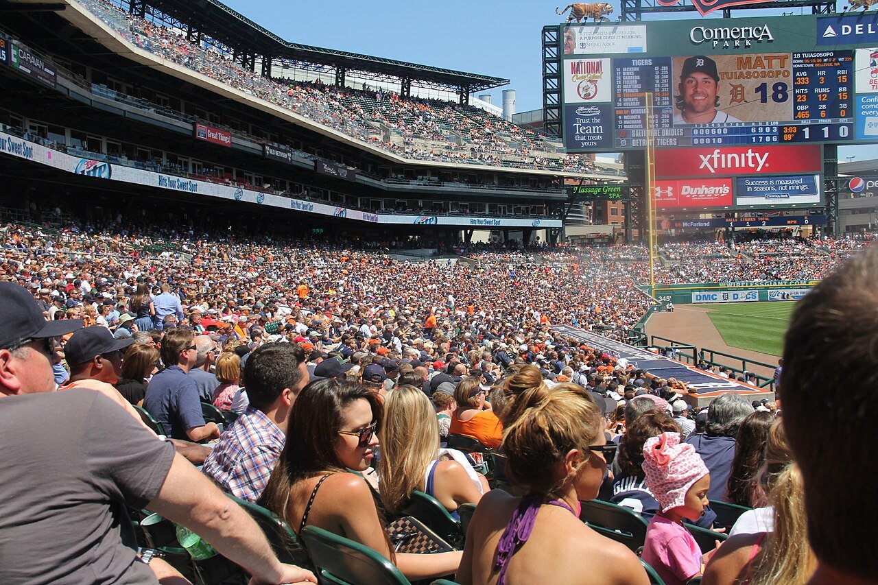 Crowded Comerica Park stands and scoreboard during a sunny baseball game.