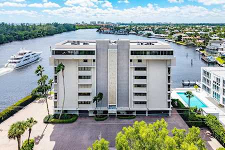 Waterfront condominium building with a swimming pool and boat on the adjacent waterway.