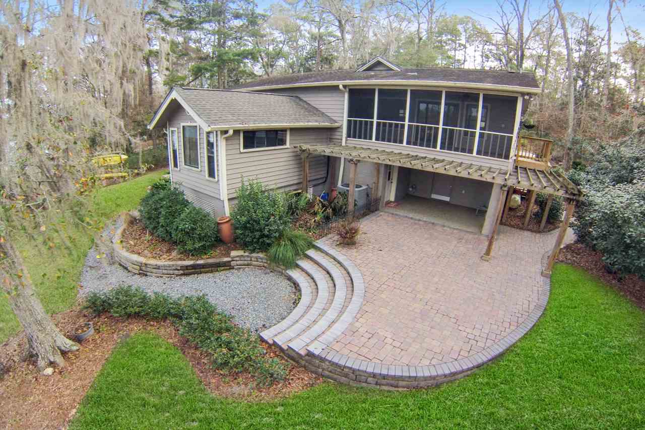 Aerial view of a home featuring a spacious deck and a large, well-maintained yard.