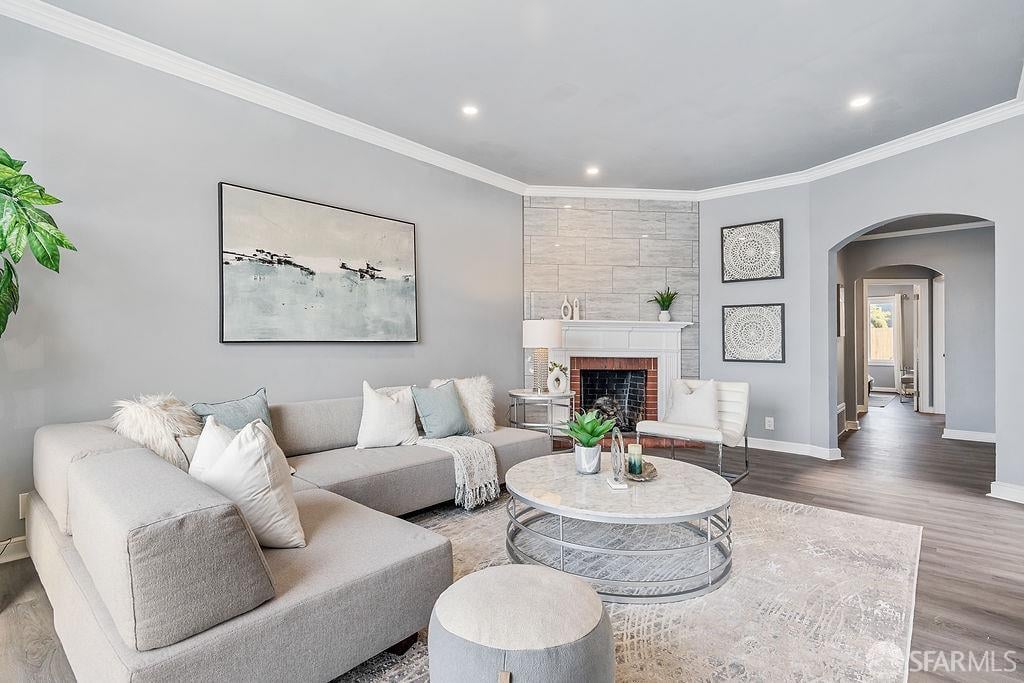 Staged living room with a gray sectional, marble coffee table, and fireplace against a stone-tile wall.