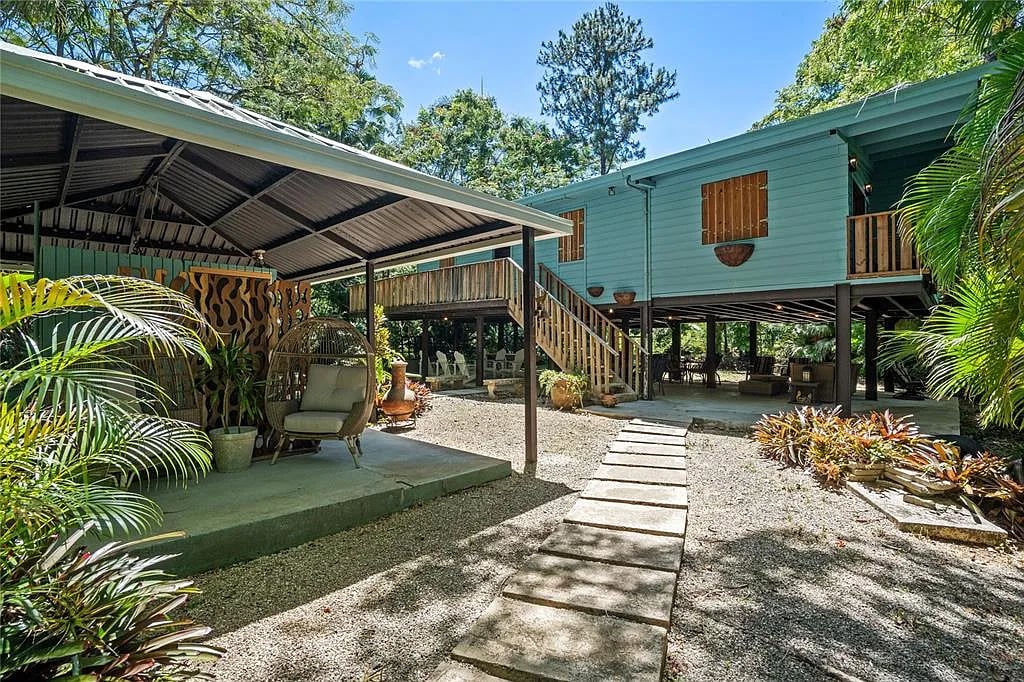 Stilted blue house with outdoor patio