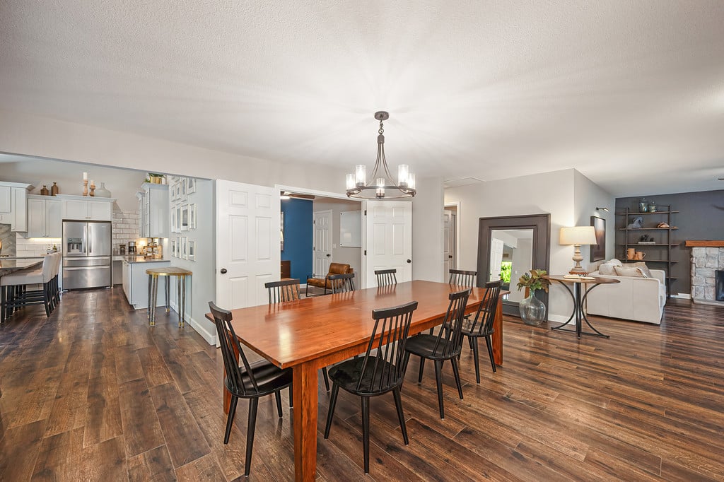 Dining room with a large wooden table, open to the kitchen and living area.