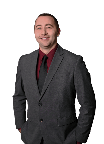 Jay Stallone in a charcoal suit, burgundy shirt, and black tie.