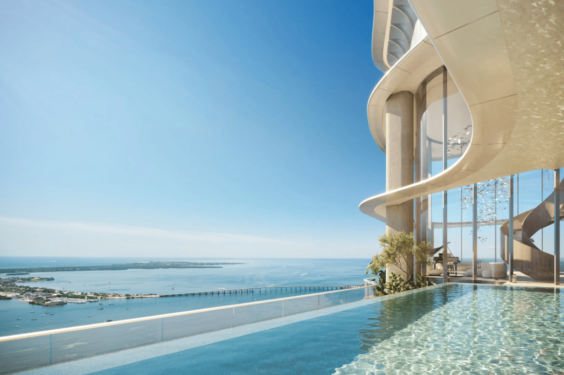 Luxury tower terrace with an infinity pool overlooking Biscayne Bay and a bridge.