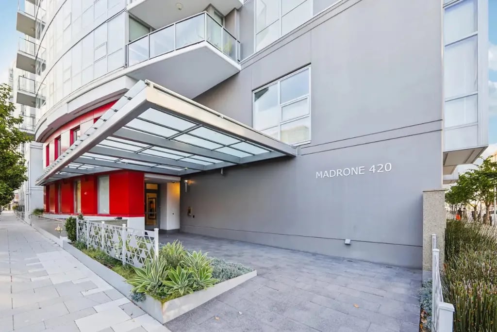 Madrone 420 building entrance showcasing contemporary gray facade, glass canopy, red design elements, and modern residential architecture in San Francisco
