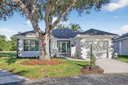 Single-story home with stone accents, a large front-yard tree, and a concrete driveway.