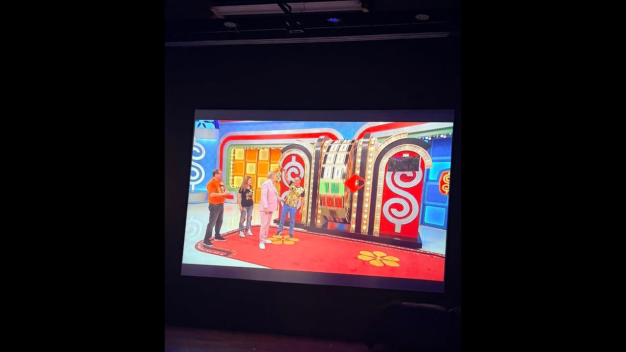 The Price Is Right set displayed on a screen during a viewing party.