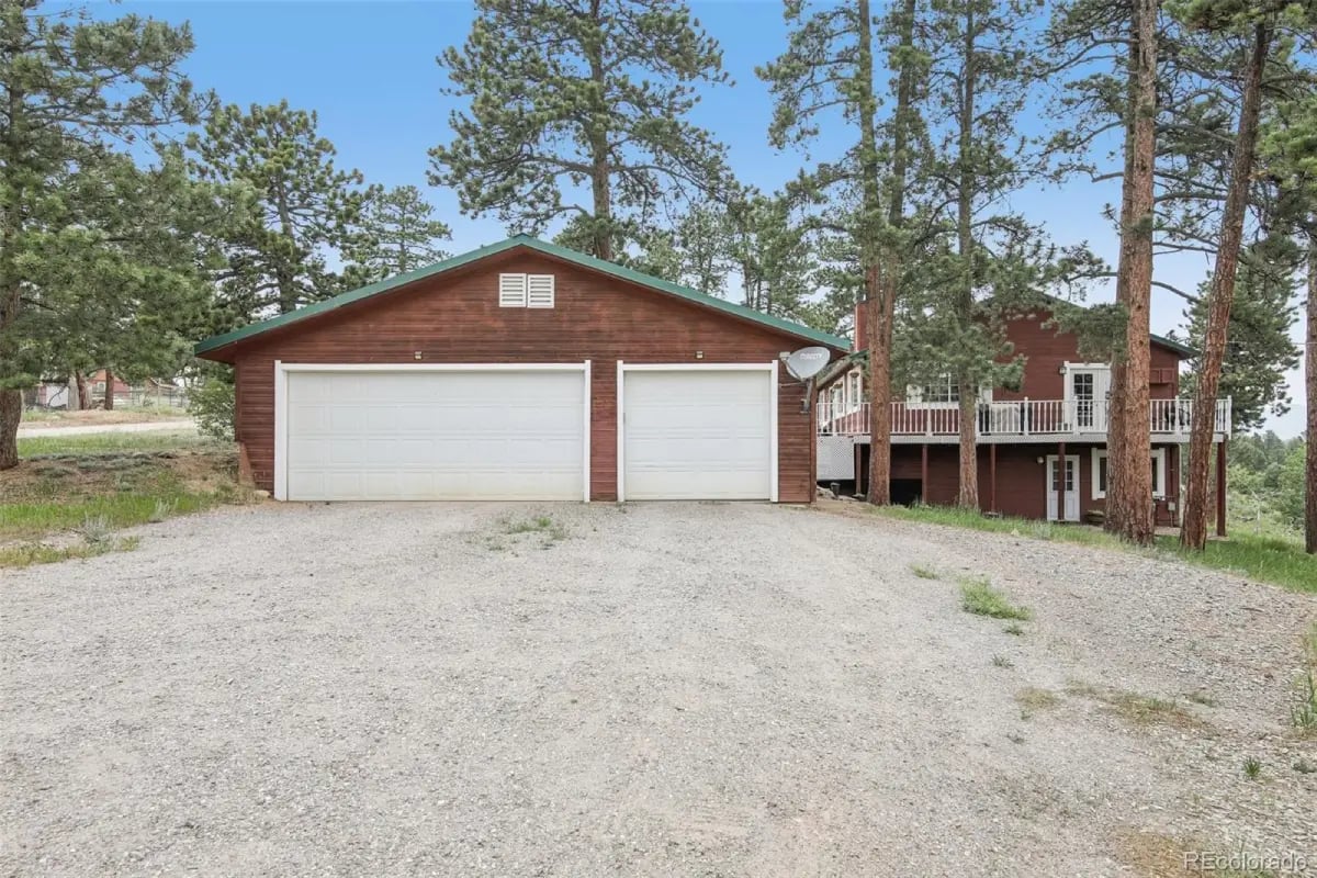 Large detached garage, gravel driveway, and pine trees at 278 Overlook Drive.