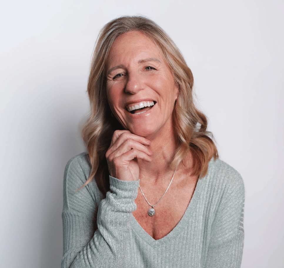 Shari McNeil smiling with her hands beneath her chin.