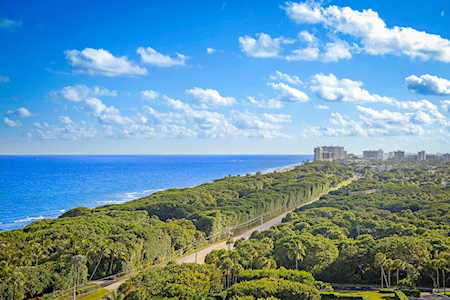 Aerial view of East Boca’s green coastline beside the ocean, with high-rises in the distance.