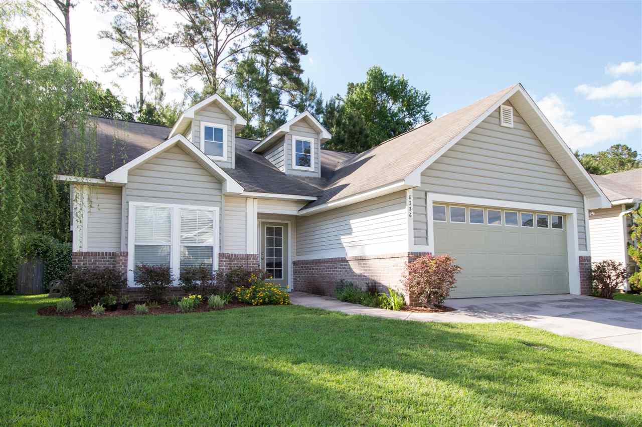 A residential home featuring a garage and a paved driveway, showcasing a welcoming exterior.