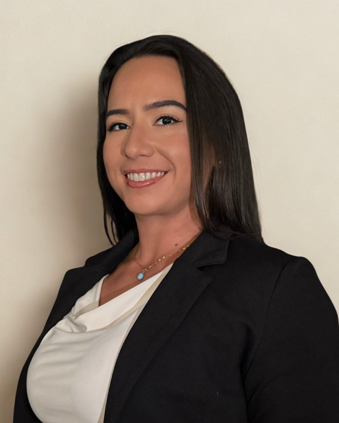 Amoricka Freitas smiling in a black blazer and white top.