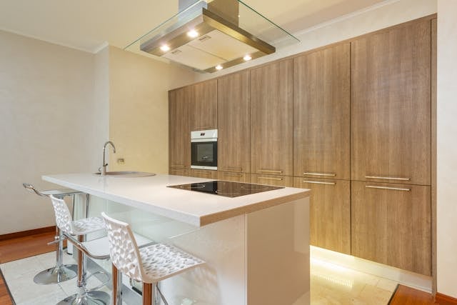 contemporary-kitchen-with-white-island-bar-stools-and-wood-cabinets