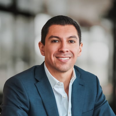 Jason Naranjo smiling in a blue suit jacket and white shirt.