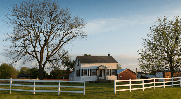 A simple white fence stands against a clear background, defining a boundary with its clean and bright appearance.