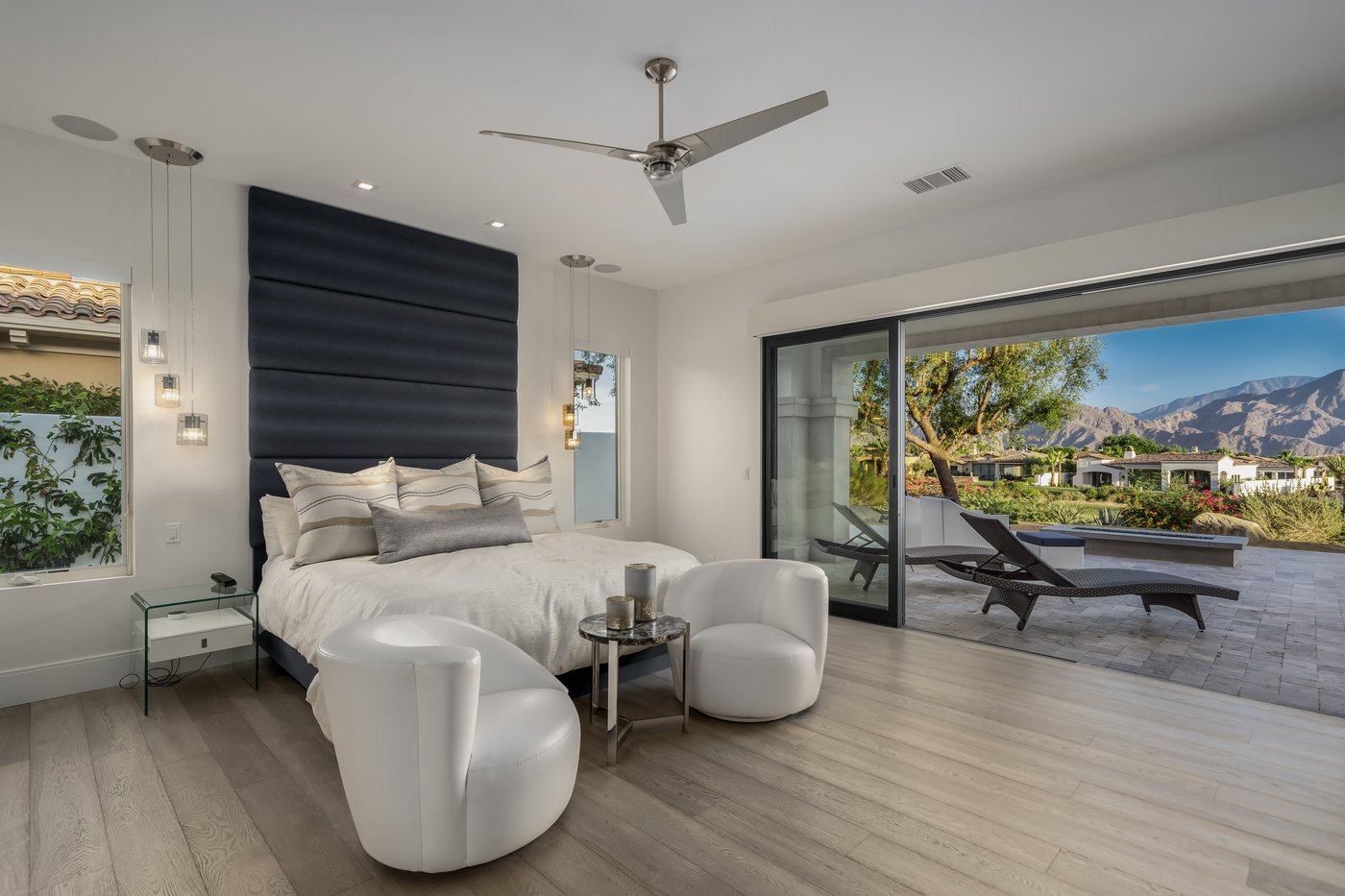 Primary bedroom with navy headboard and sliders open to the patio at Toscana Country Club