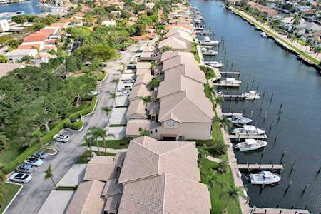 Waterfront homes and boats along a canal, seen from above.