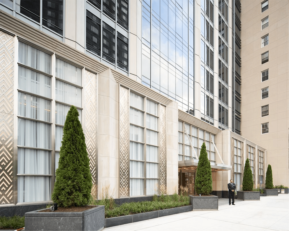 200 Amsterdam Avenue’s glass-and-stone facade with landscaped planters and a recessed entrance.