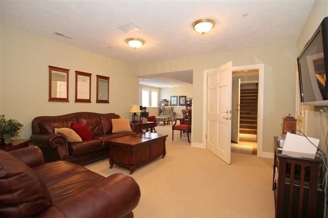 Living room with leather sofas and a wooden coffee table, opening to adjoining rooms.