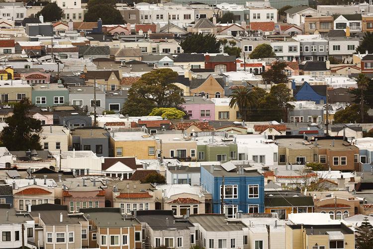 Dense neighborhood of closely packed homes in varied colors and architectural styles.