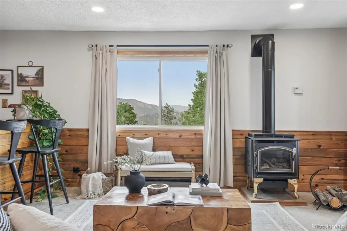 Cozy living room interior at 278 Overlook Drive featuring a large center window with a scenic mountain and forest view.
