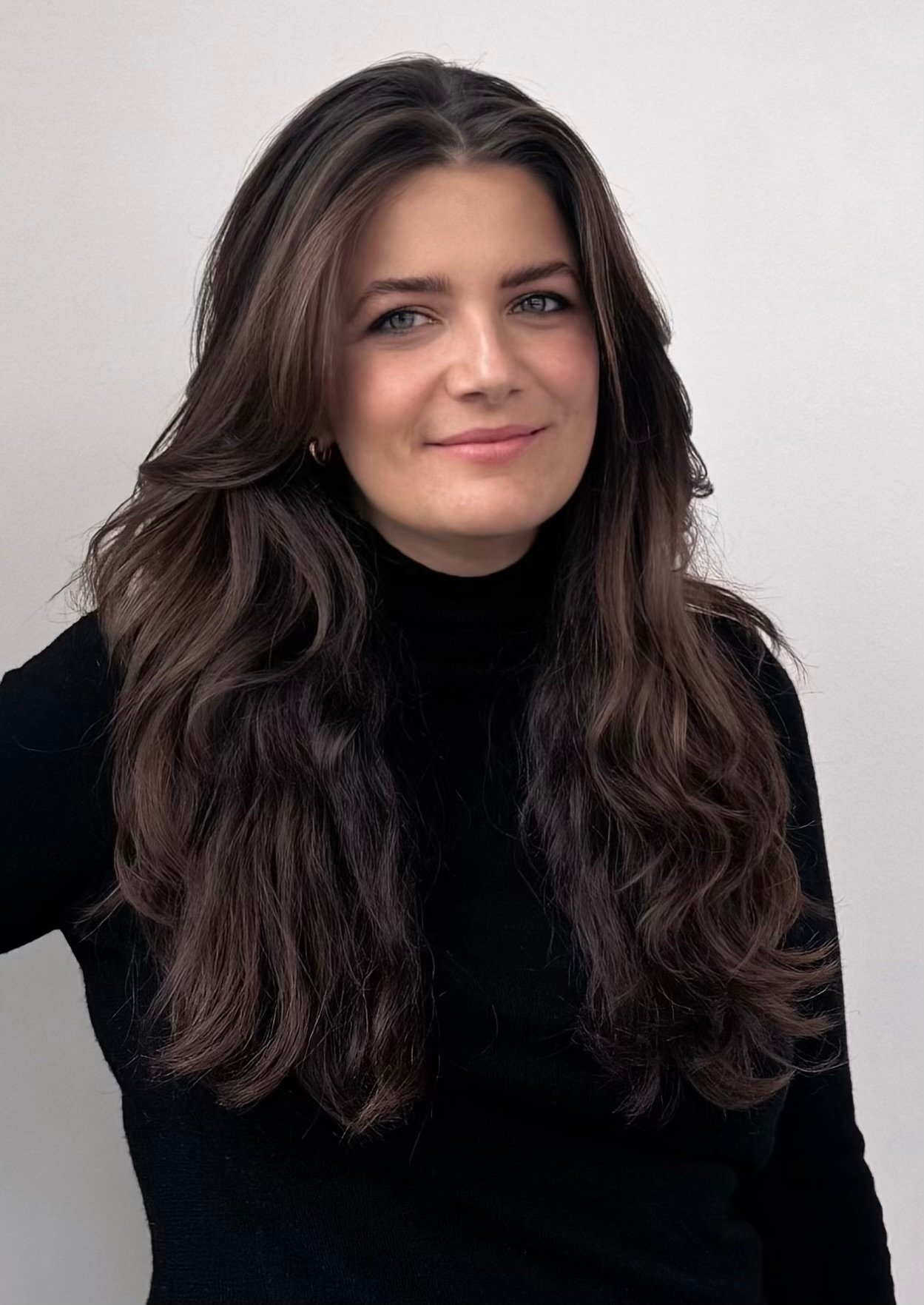 Anait Tamanian in a black top with long, wavy dark hair.