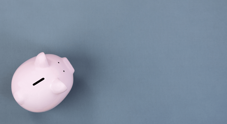 A pink piggy bank sits on the left against a plain blue background, symbolizing savings. The image conveys simplicity and financial planning.