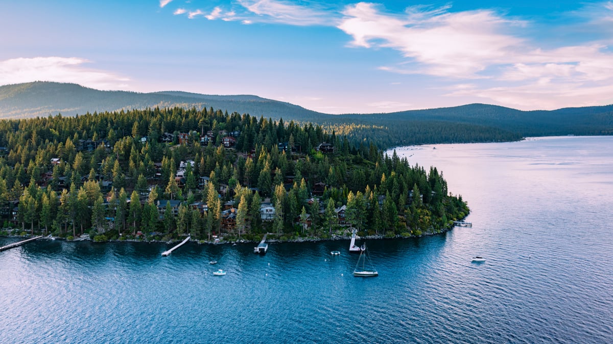 Aerial of forested peninsula with lakefront homes