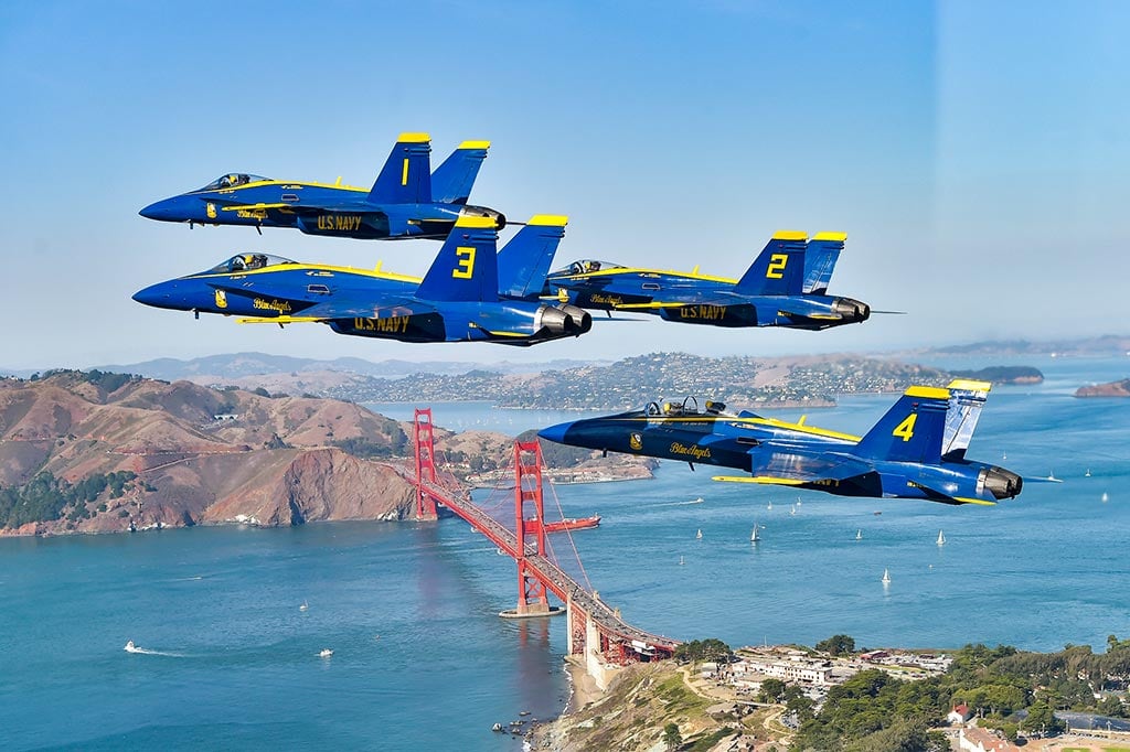 Blue Angels fighter jets flying in formation above San Francisco's Golden Gate Bridge