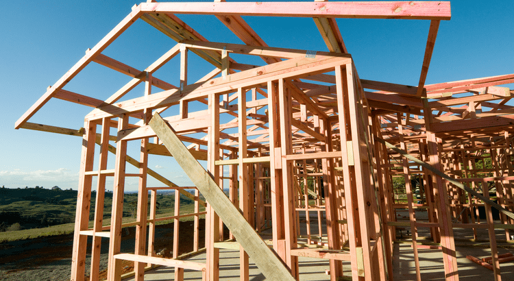 A partially built house with scaffolding and construction materials visible, showcasing the ongoing construction process.