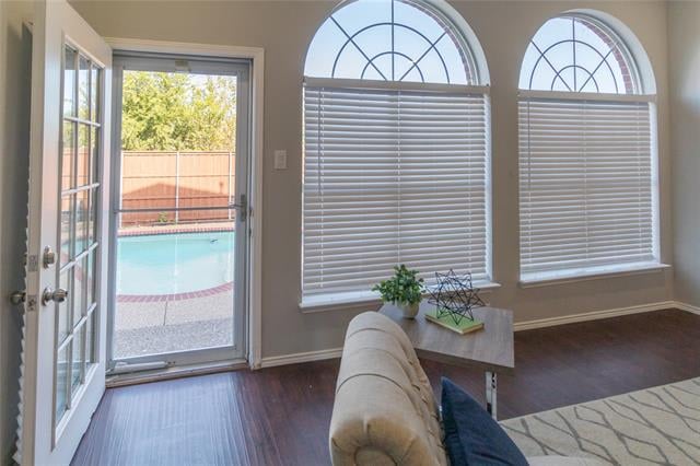 Living room with arched windows and an open door overlooking the pool.