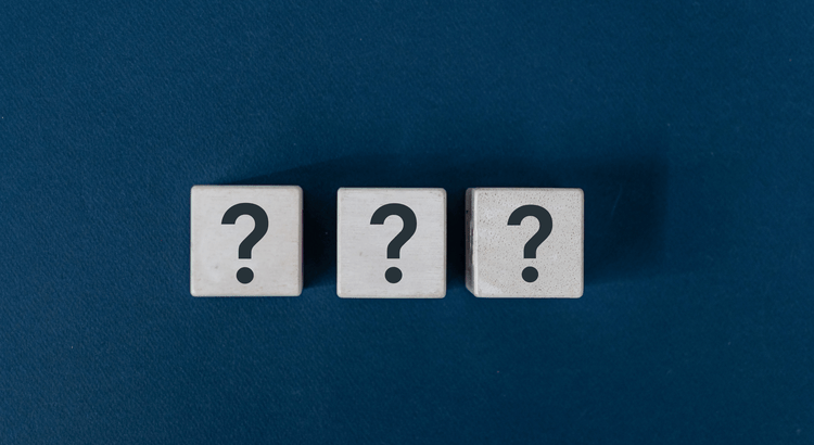 Three white cubes featuring question marks, set against a vibrant blue background.
