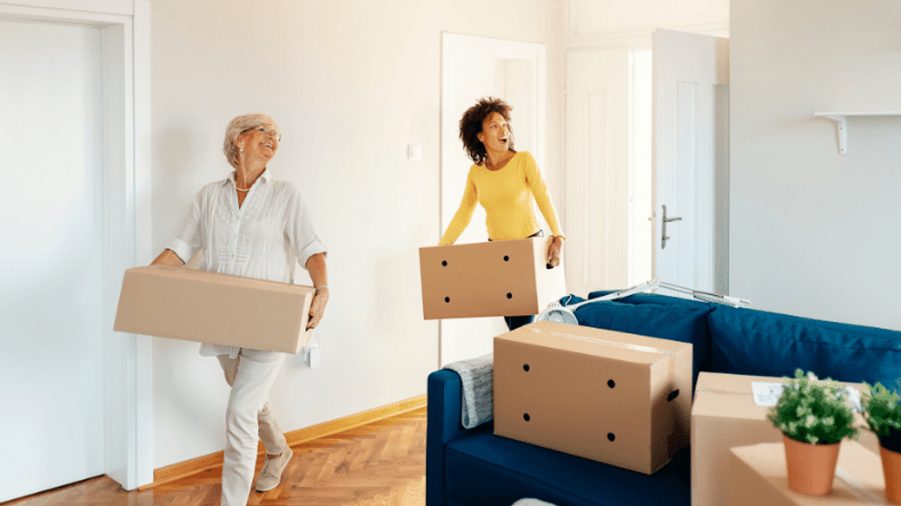 Parents and adult child standing together outside a New York City apartment building