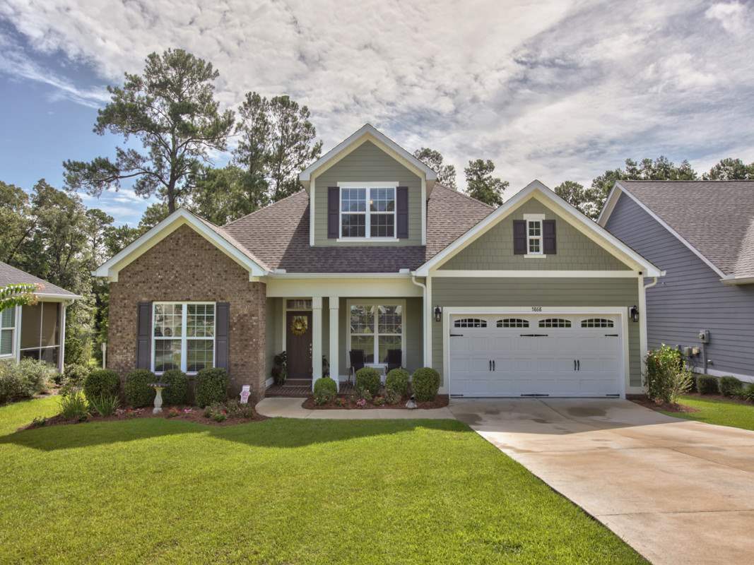 A charming suburban home featuring a well-maintained lawn and traditional architectural design.