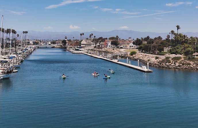 Channel Islands Harbor marina slips lined with boats near Hollywood Beach homes in Oxnard