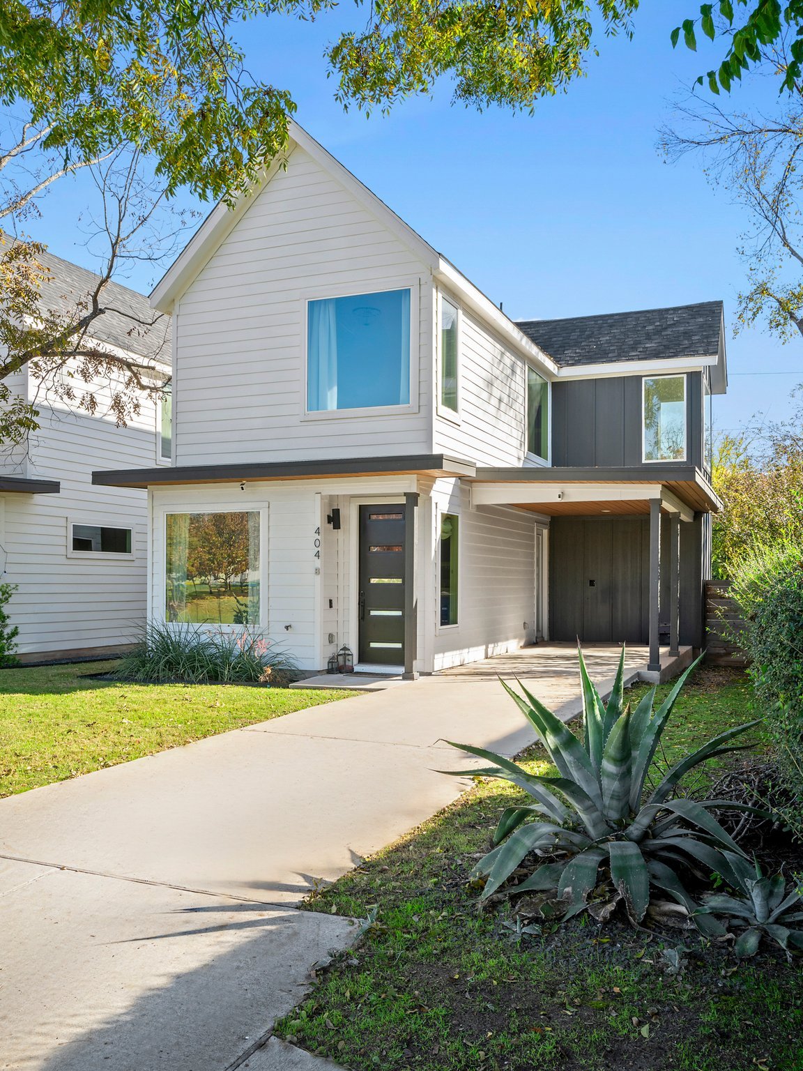 Front elevation of 404 Powell Cir Unit B, a modern farmhouse-style home in Austin's Dawson neighborhood, with agave landscaping along the front walk.
