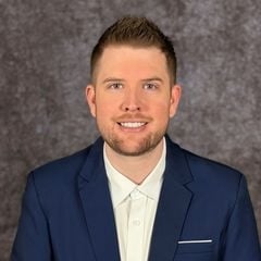 Kyle Kidwell in a navy suit and white shirt.