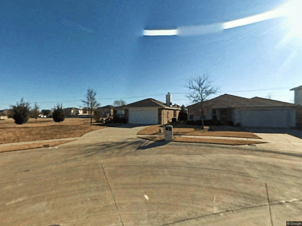Single-story brick home with an attached garage and broad concrete driveway.