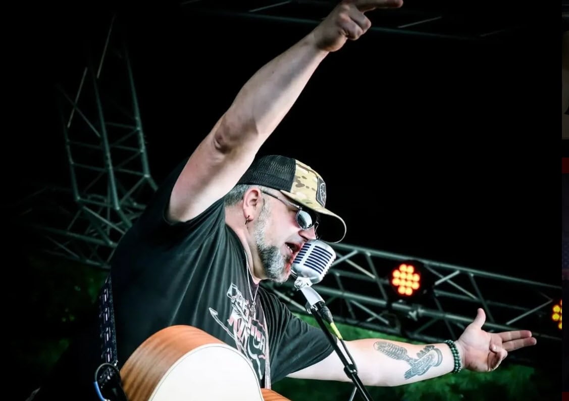 Jason Passmore on stage playing a guitar and singing he will be at the vignette realty's sponsored Sweet Carolina Music Festival
