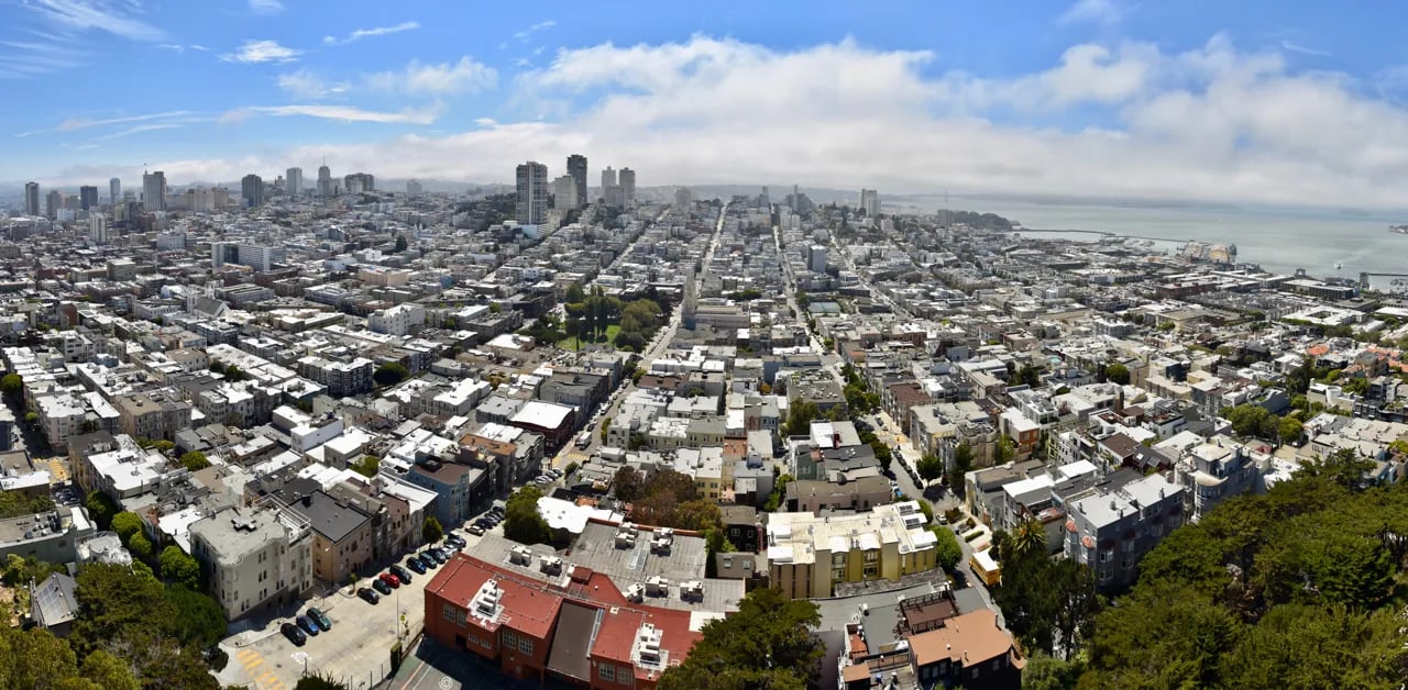 Panoramic view from Coit Tower showing San Francisco Bay, downtown skyline, and Telegraph Hill neighborhood