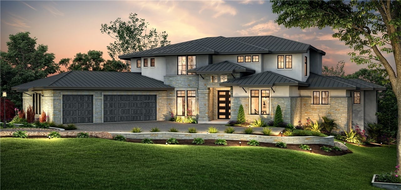 Two-story home with a stone facade, dark metal roofs, and a landscaped front lawn at dusk.