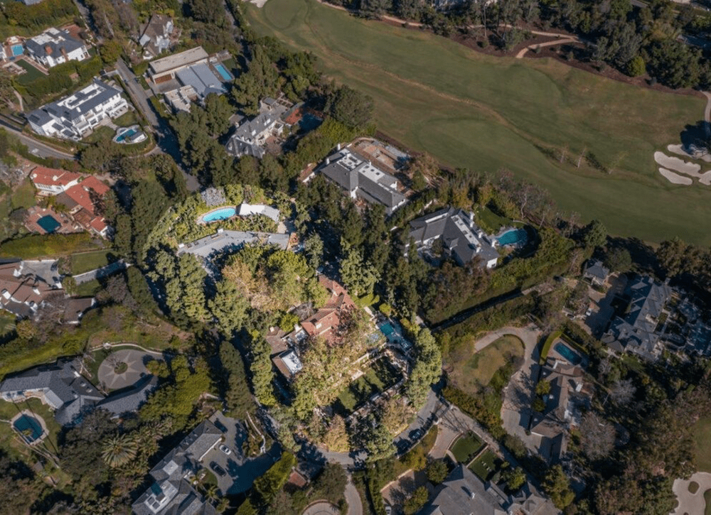 Aerial view of homes beside a golf course, with pools and tree-lined lots.