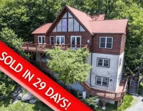 Mountain home with wraparound decks and a red “SOLD IN 29 DAYS!” banner.