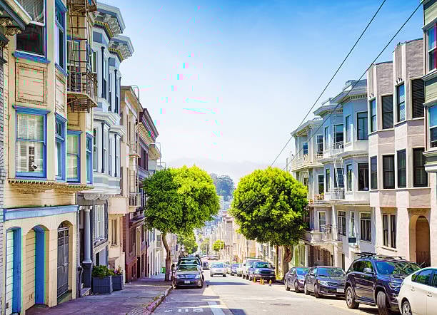 A tree-lined street in Pacific Heights with elegant architecture and well-maintained gardens