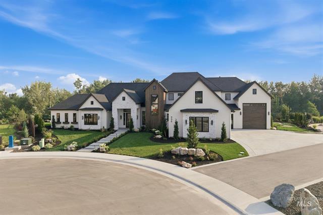 White modern farmhouse with dark trim, landscaped front yard, and attached garage on a curved street.
