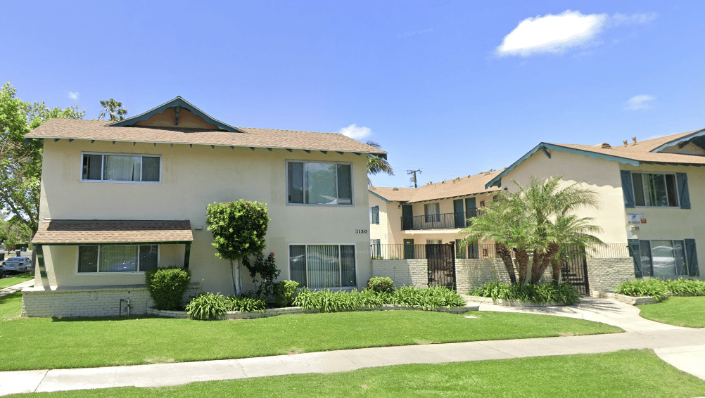 Two-story apartment complex marked 1130, with landscaped grounds and a broad front lawn.