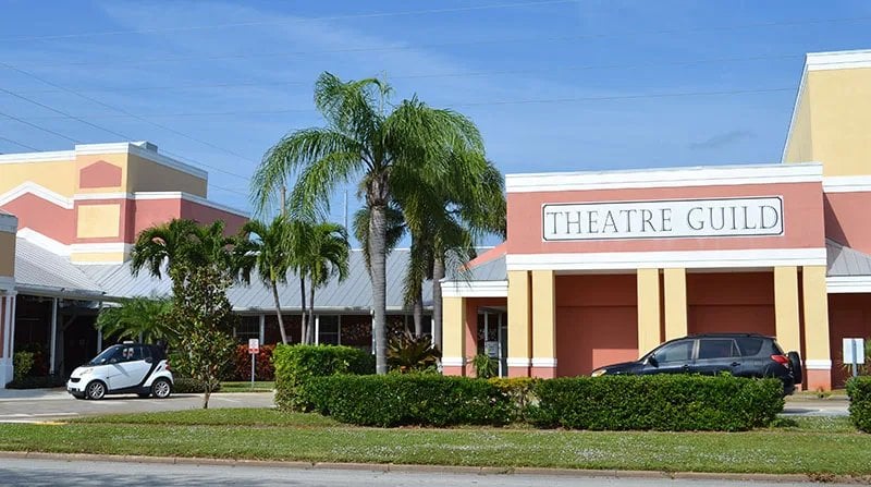 Vero Beach Theatre Guild building with palm trees under a blue sky